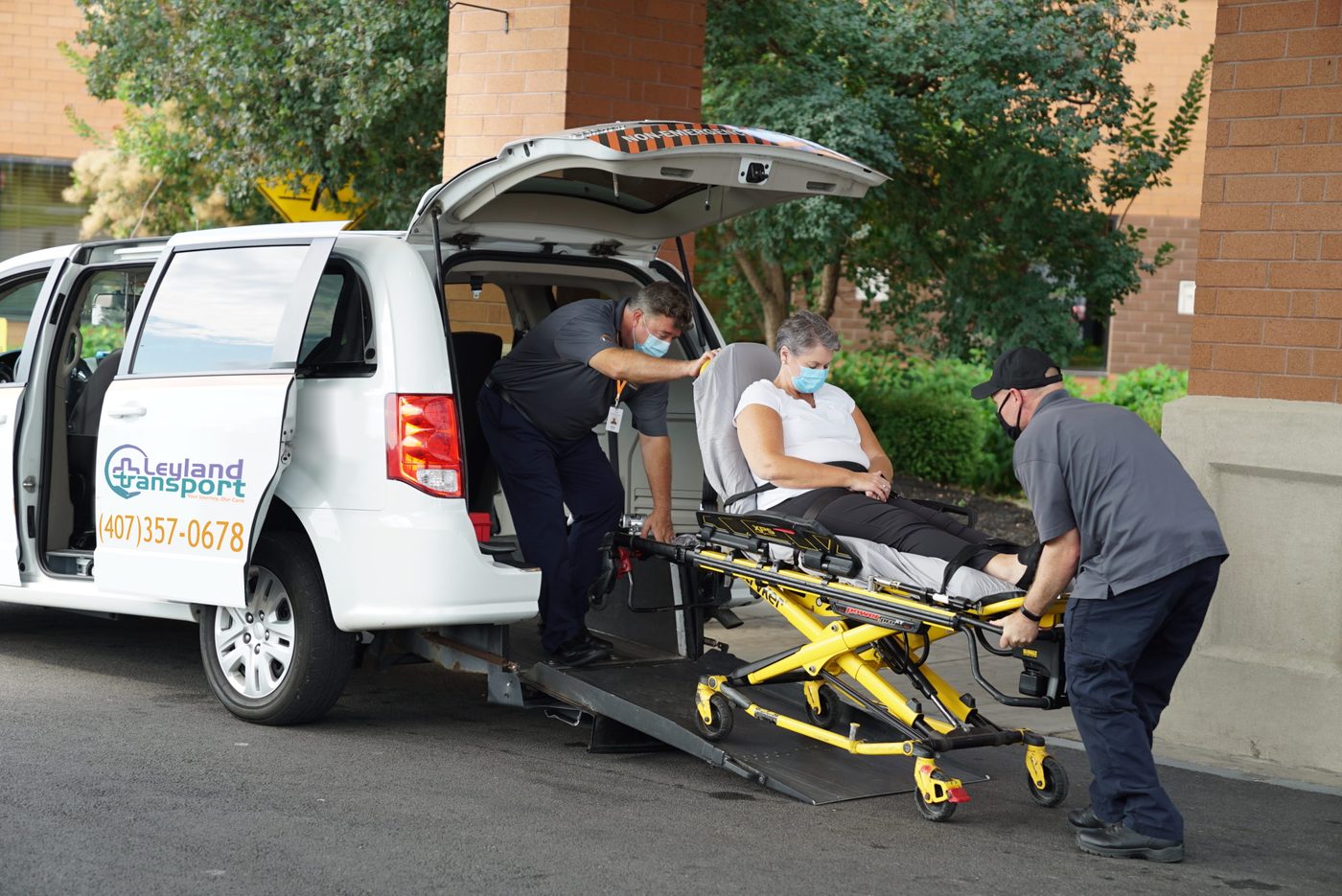 Leyland Transport team assisting a patient with wheelchair lift transport